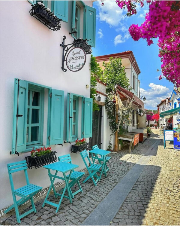 Sığacık'ta turkuaz panjurlu taş evler ve begonviller
